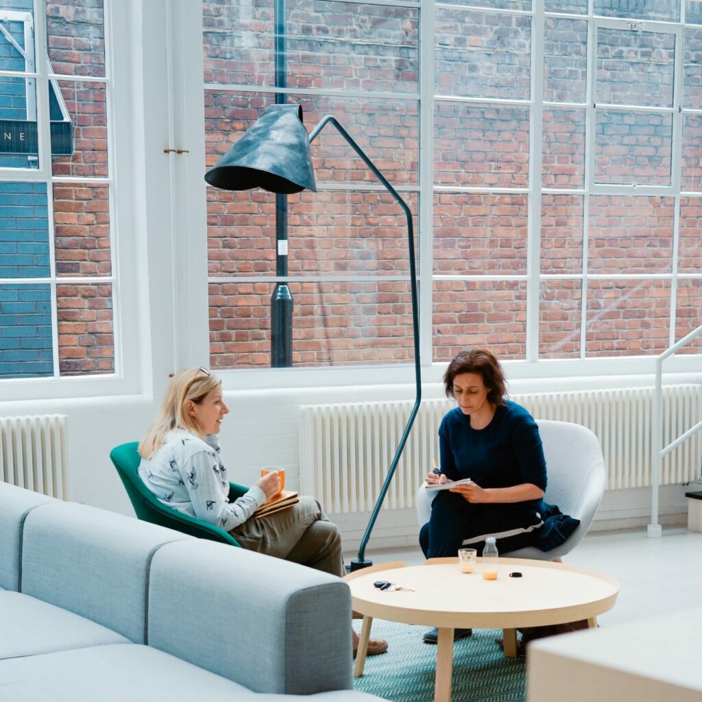 Deux femmes en réunion professionnelle sur des fauteuils